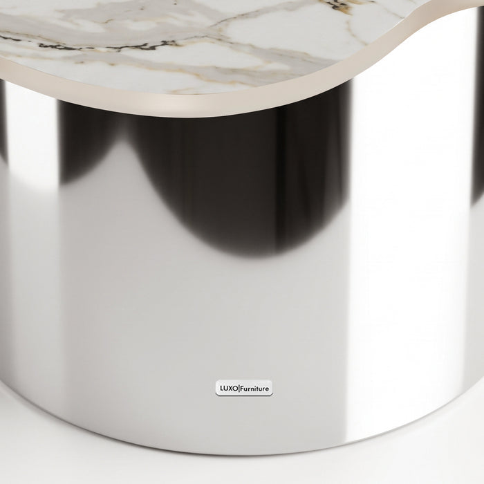 Close-up of a luxury table with a reflective metallic base and marble-like top on a white background