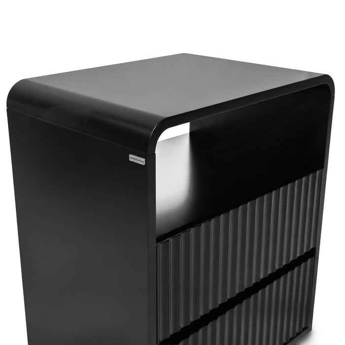 Modern black storage unit with rounded top and grooved lower section on white background