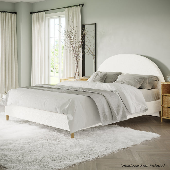 Celina Queen Boucle Fabric Bed Base in Cream White, featuring textured upholstery, low-profile design, plush linens, and sturdy timber legs, nestled on a shaggy rug in a bright, minimalist bedroom setting.