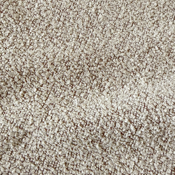 Close-up of warm beige boucle fabric texture with woven looped yarn pattern