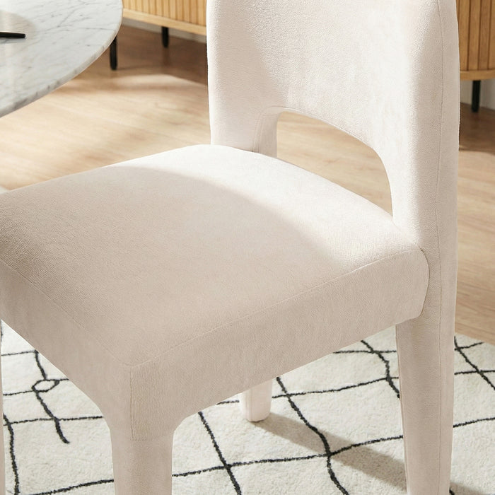 Close-up of Edris dining chair in oat upholstery showing curved backrest and seat detail