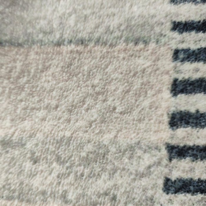 Close-up of Elimas 200x300cm Soft Contemporary Printed Floor Rug, showcasing its plush terrycloth surface with a subtle pattern and darker striped edge, highlighting its inviting texture and modern design.