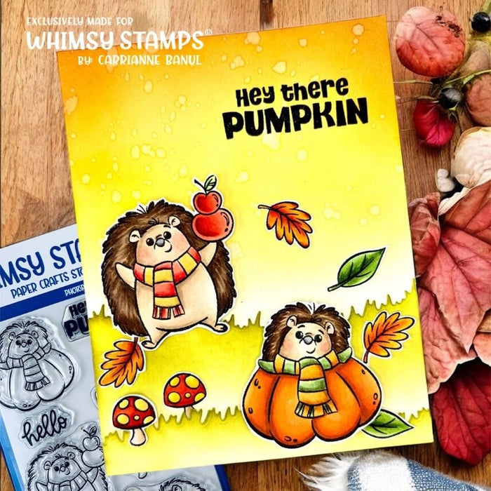 A handmade card featuring two hedgehogs wearing scarves, one holding apples and one sitting in a pumpkin, with a yellow-to-white gradient background and text that reads 'Hey there PUMPKIN'