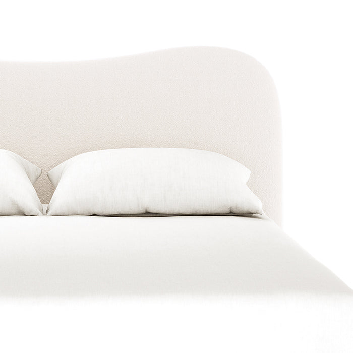 Ginnie Bouclé Curved Double Bed Frame - Cream White, featuring a softly curved, upholstered headboard in cream fabric with matching pillows, neatly made coverlet, and sturdy timber legs for a modern bedroom look.
