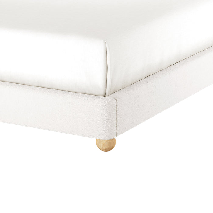Ginnie Bouclé Curved Double Bed Frame in Cream White, featuring a plush upholstered frame with a fitted mattress on a single rounded, light-wooden leg. Ideal for minimalist, modern interiors.