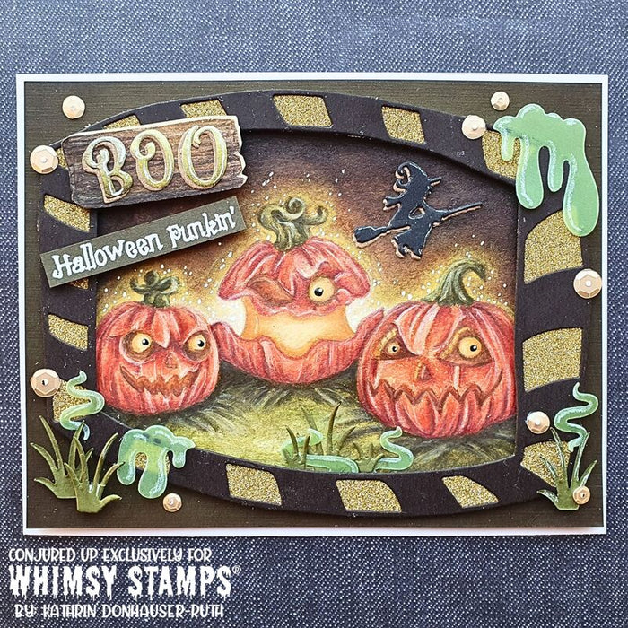 A handmade Halloween card featuring three carved pumpkins, a witch on a broomstick, green slime, grass, and a wooden-style 'BOO' sign on a dark striped border.