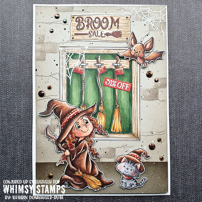 A handmade Halloween card featuring a witch in a broom shop, with a bat and a cat in a witch hat. A sign in the top center reads 'Broom Sale.'