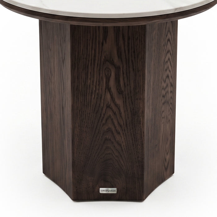 Partial close-up of a round table base with dark wood finish on a white background