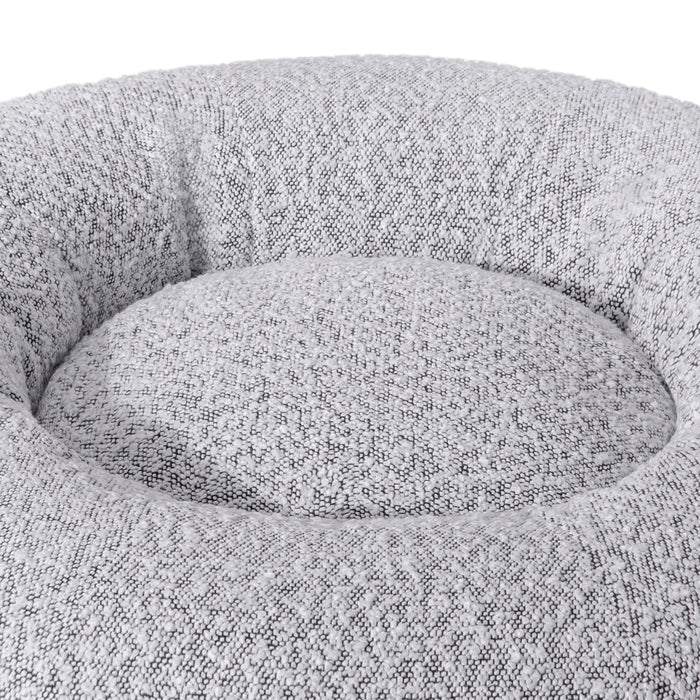Kyra Medium Boucle Pet Bed – White with Black Base features soft curves, raised bolsters, and a plush white texture, offering ergonomic comfort and modern style with a non-slip black base for stability.