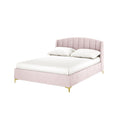 Lyra Velvet Bed Frame with Winged Headboard - Soft Pink Double, showcasing a blush-pink vertically tufted headboard, white linens, and slender brushed brass legs, ideal for minimalist, feminine bedroom decor.