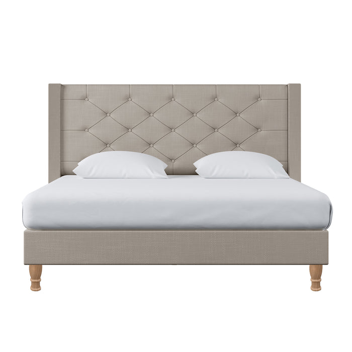 Maggie Queen Winged Fabric Bed Frame in Warm Grey features a button-tufted upholstered headboard, white bedding, and wooden legs, exuding elegance and stability with a Chesterfield-style design.