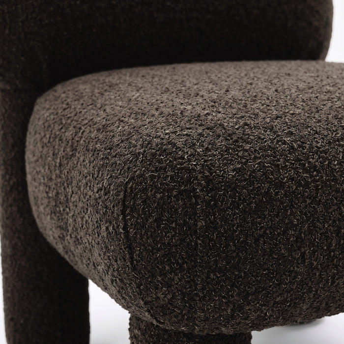 Close-up of dark brown boucle fabric and cushion edge of chair