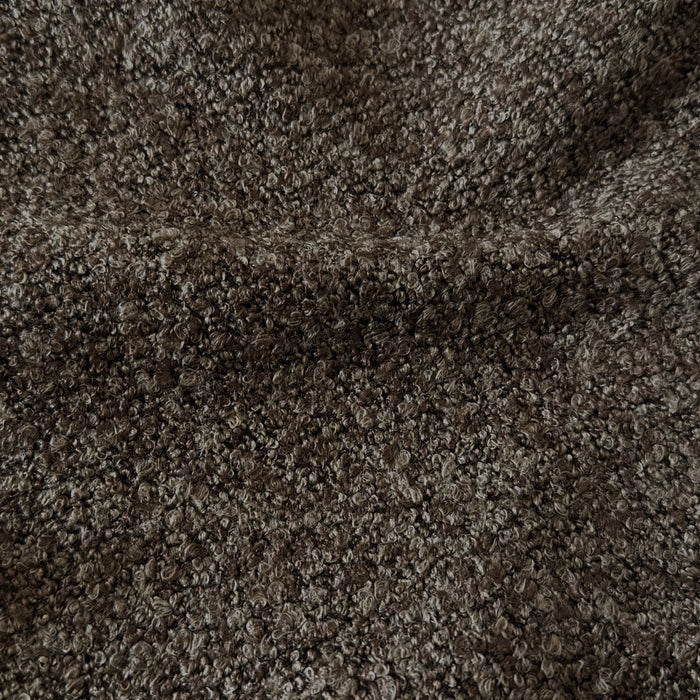 Very close-up view of dark brown bouclé fabric texture