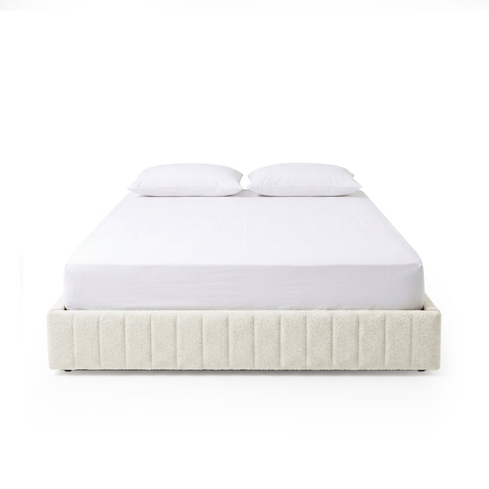 Modern bed frame with vertical channel upholstery and two white pillows on a white background